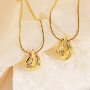 Gold-plated water drop zircon necklace with irregular geometric pendant on beige silk