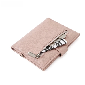 Detail of pink pebbled leather passport wallet showing external silver zipper coin pocket