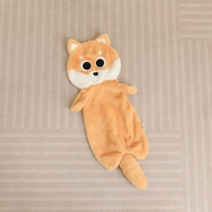 Detail of soft plush orange shiba inu dog pillow case with large cute black eyes