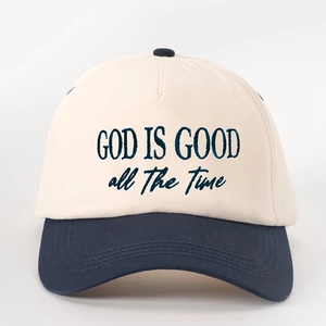 Detailed embroidery of 'GOD IS GOOD' on beige and navy blue two-tone baseball cap