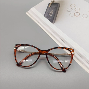 Detail of tortoise shell cat-eye glasses frame with sleek golden metal spring legs