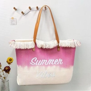 Close-up of pink gradient beach tote with Summer Vibes text and white fringe trim