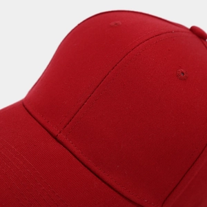 Detailed close-up of red cotton twill baseball cap with reinforced stitching and eyelets