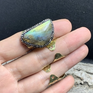 Detailed view of wide gold ring featuring an irregular labradorite stone with blue flash