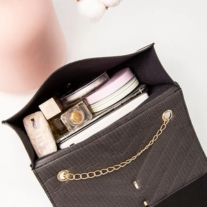 Black tassel crossbody bag with gold chain showing spacious interior for essentials
