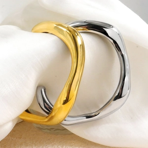 Minimalist irregular wave-shaped open bangles in gold and silver finish on silk