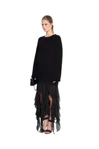 Detail of oversized chunky knit sweater paired with asymmetrical layered ruffle skirt