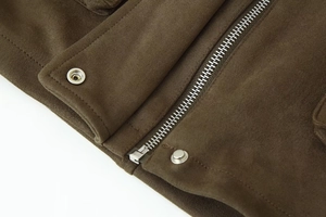 Detailed macro view of metal zipper and snap button on olive faux suede bomber jacket