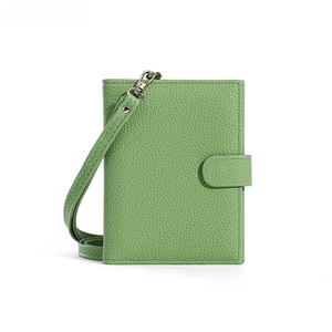 Detail showing genuine leather green passport wallet with lychee texture and wrist strap