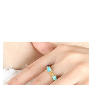 Close-up of a gold-plated titanium ring featuring three engraved turquoise zircon stones