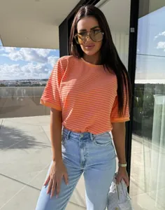 Gros plan sur le tissu en maille rayé orange et rose d'un t-shirt d'été décontracté