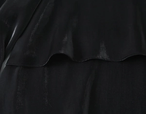 Detailed view of the smooth black satin fabric with natural luster and soft draping effect
