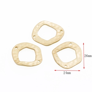 Macro shot of three 26mm gold-toned textured pentagon jewelry connectors on white background