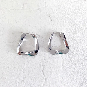 Macro shot of silver irregular geometric square earrings with a polished metallic finish