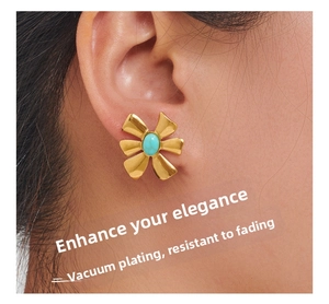 Detail of flower-shaped gold earring with turquoise stone inlay on a model