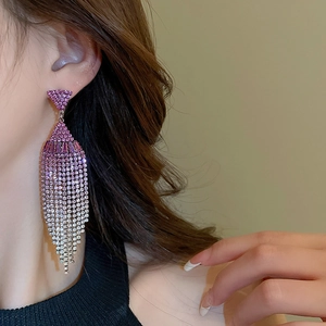 Macro view of long rhinestone tassel earrings with a pink to silver gradient finish