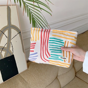 Detailed close-up of corduroy makeup bag featuring colorful abstract geometric stripes