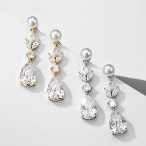 Detailed view of luxury leaf-shaped zircon and pearl drop earrings in gold and silver