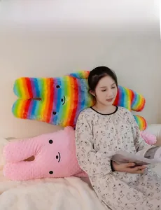 Detail of plush rabbit pillows in rainbow and pink textures shown with a model