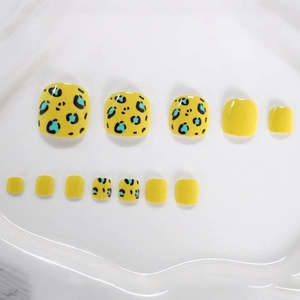Short square press-on toenails featuring bright yellow base and blue leopard print