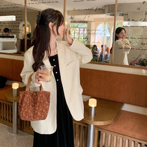 Lifestyle view of a vintage corduroy tote bag with orange floral patterns in a cafe setting