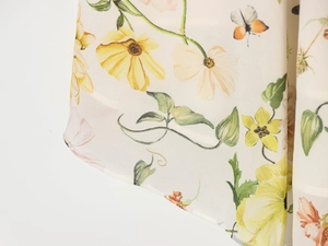 Détail du tissu en mousseline à fleurs jaunes et roses avec des papillons orange