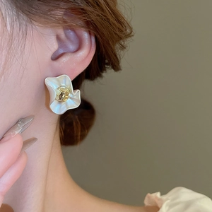 French style white flower stud earrings with gold hammered center on a female model