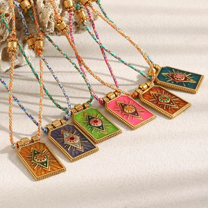 Detail of colorful woven cord necklaces with gold plated enamel evil eye pendants