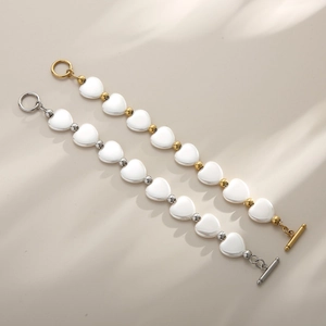 Détail de perles de cœur et fermoir OT or/argent sur des bracelets minimalistes