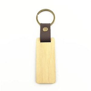 Close-up of rectangular wooden keychain with brown leather strap and bronze metal ring