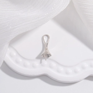 Vue macro d'une bélière en argent en forme de cloche pour pendentif perle DIY