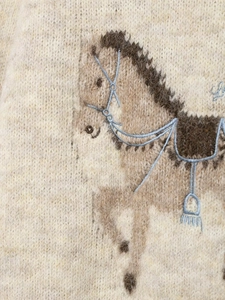 Close-up of horse motif embroidery on oatmeal wool blend knit sweater detail