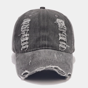Gros plan sur les détails déchirés et la texture délavée de la casquette anthracite