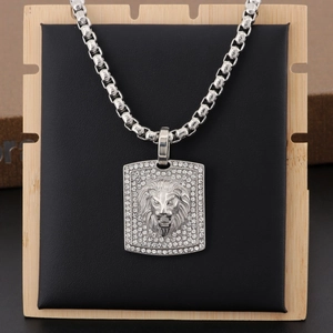 Close-up of square silver lion head pendant with crystal pavé on a black display stand