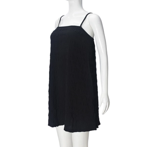 Detail view of black pleated A-line slip dress fabric texture on a white mannequin
