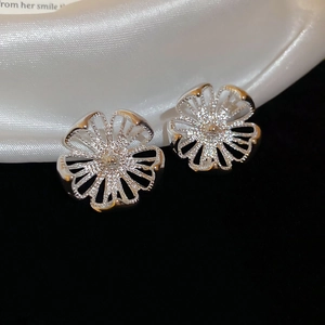 Detailansicht der hohlgeformten Blumenohrstecker in Silber auf schwarzem Hintergrund