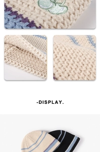 Close-up of beige chunky knit hat featuring blue stripes and cherry embroidery detail