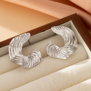 Artistic silver C-shaped stud earrings with ripple texture in a velvet jewelry box
