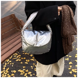 Metallic silver padded tote bag shown in an autumn setting with yellow leaves