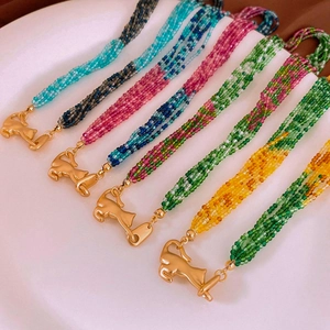 Detail of multi-layer crystal bead necklaces with golden leopard-shaped clasps