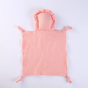 Close-up of pink muslin cotton baby security blanket with ruffled head and knotted corners