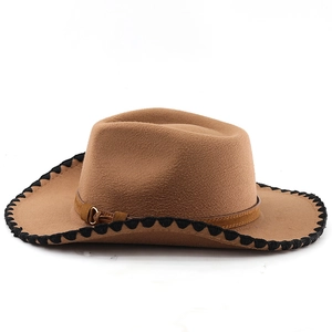 Close-up of brown wool felt cowboy hat with wavy black stitching and gold buckle detail