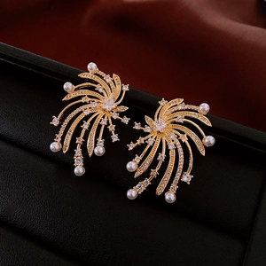 Macro detail of gold starburst earrings with white pearls and sparkling cubic zirconia