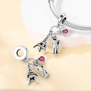 Macro detail of silver travel charms featuring Eiffel Tower and Liberty Statue beads