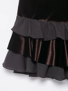 Détail de la mini-jupe en velours noir et mousseline avec des volants superposés