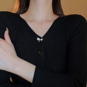 Détail d'une broche nœud en zircon étincelant sur un gilet noir pour femmes élégantes