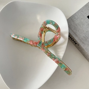 Detailed view of 13cm marble pink acetate hair claw with elegant golden metal spring