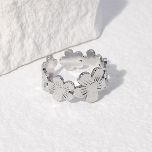 Macro view of silver stainless steel open ring featuring detailed flower patterns