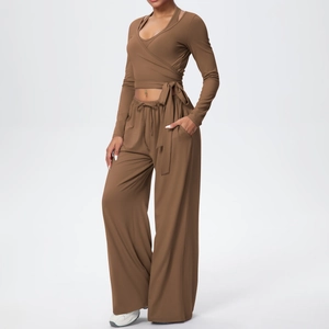 Détail d'un ensemble de yoga marron avec haut croisé et pantalon large à taille haute