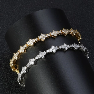 Detailed view of gold and silver four-leaf clover bracelets with shimmering cubic zirconia
